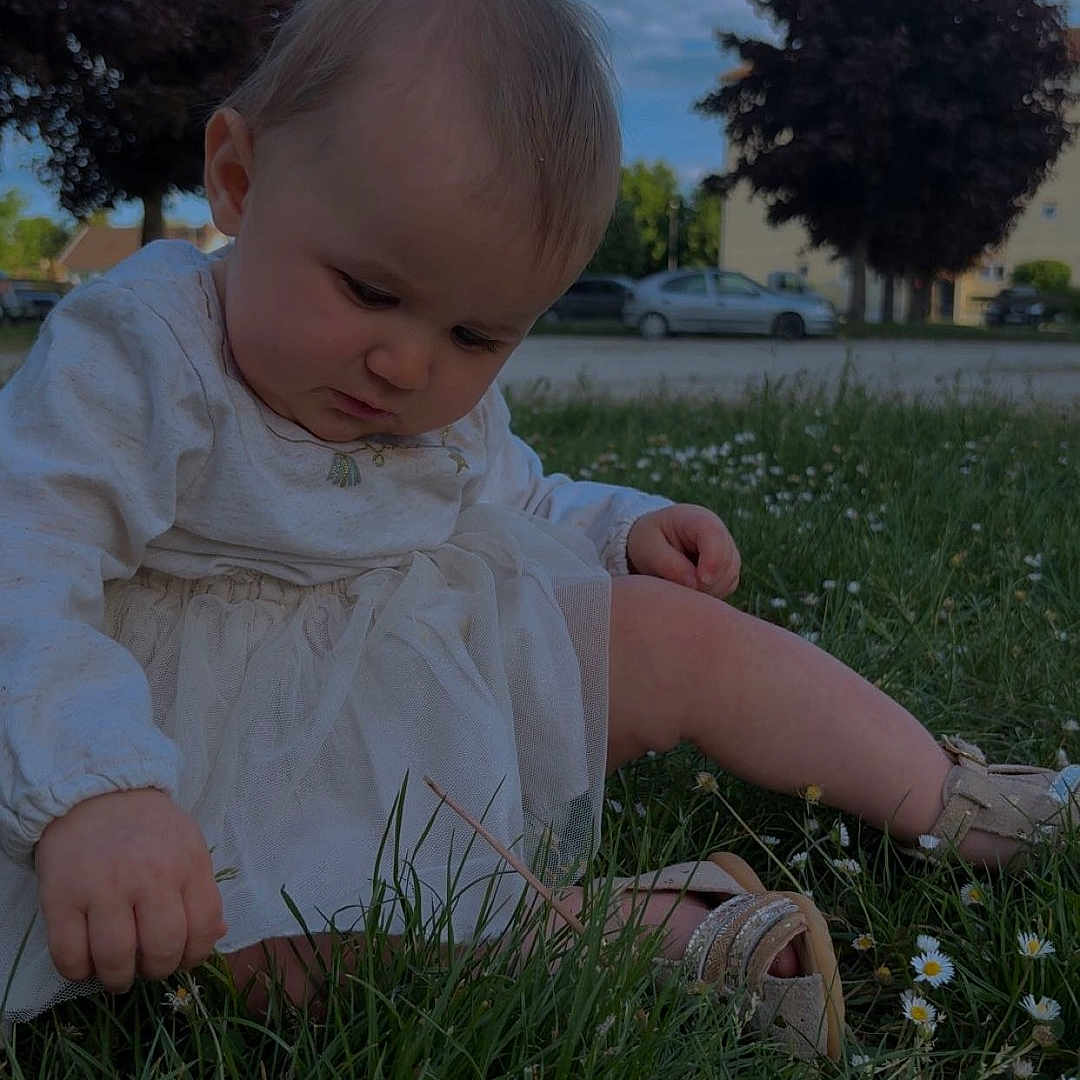 Héleanah a rejoint le concours — aidez-le/la à gagner de superbes lots ! child, clouds, curious, daisies, daylight, exploring, flower, grass, greenery, nature, outdoor, person, shoes, sitting, sky, suburban, summer, toddler, trees, white_dress