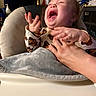 baby, infant, child, laughing, smiling, happy, portrait, face, hands, adult, caregiver, butterfly, clothing, blanket, cushion, chair, indoor, home, air_conditioner, joy