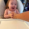 baby, child, infant, smiling, laughing, high_chair, portrait, indoors, kitchen, adult_arm, family, happy, joyful, seated, pink_clothing, face, hands, tray, home, candid