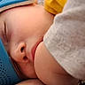 baby, blanket, blue_object, bundled, cheek, close_up, cozy, eyes_closed, face, gray_fabric, indoors, infant, nose, peaceful, photography, portrait, resting, sleeping, soft_lighting, yellow_fabric