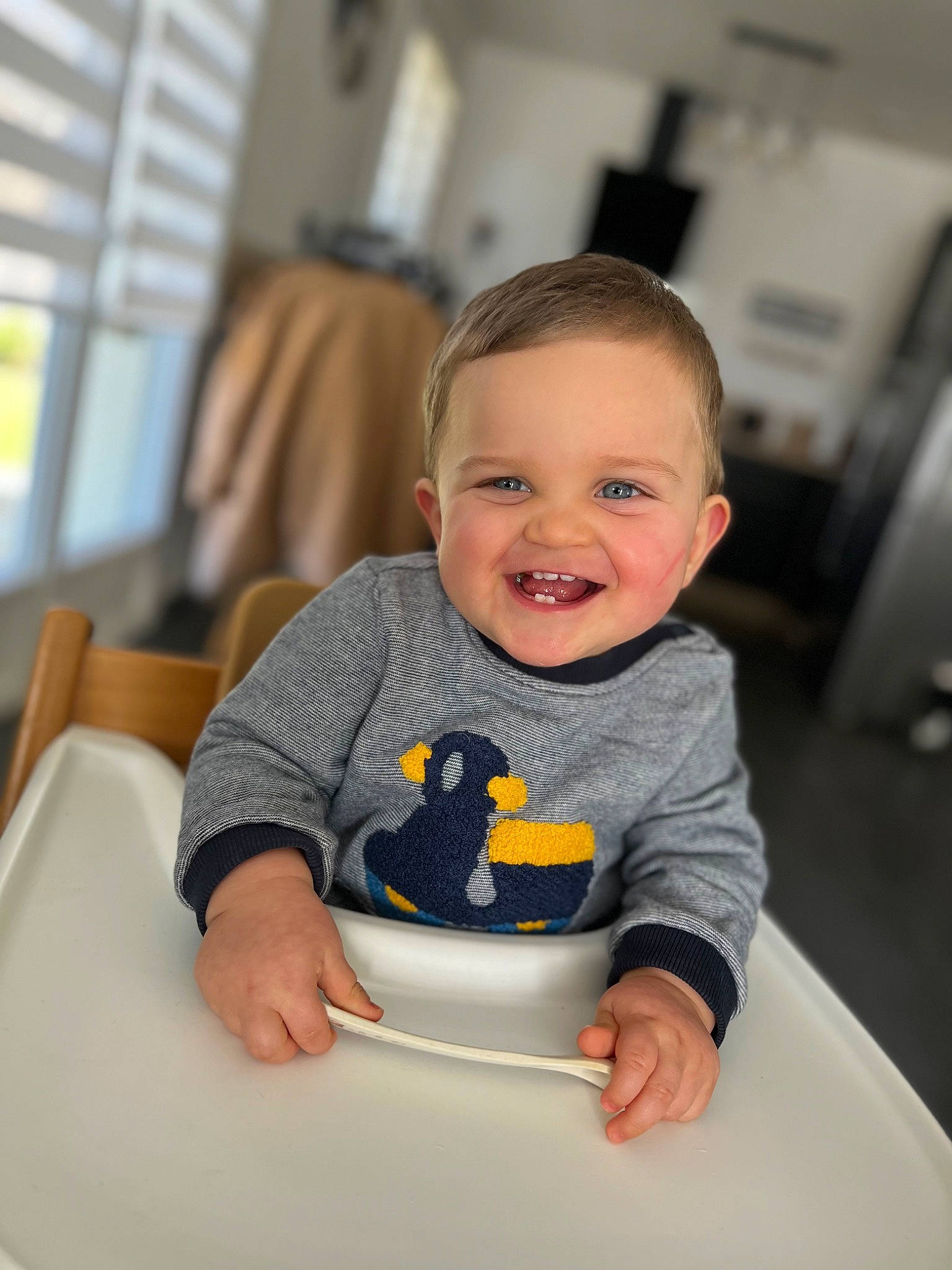 Antonin participe au concours pour gagner de l'argent avec cette photo : baby, baby_toddler_clothing, bib, chair, cheek, child, dishware, eye, face, facial_expression, flooring, fun, hairstyle, happy, head, joy, person, sleeve, smile, t_shirt