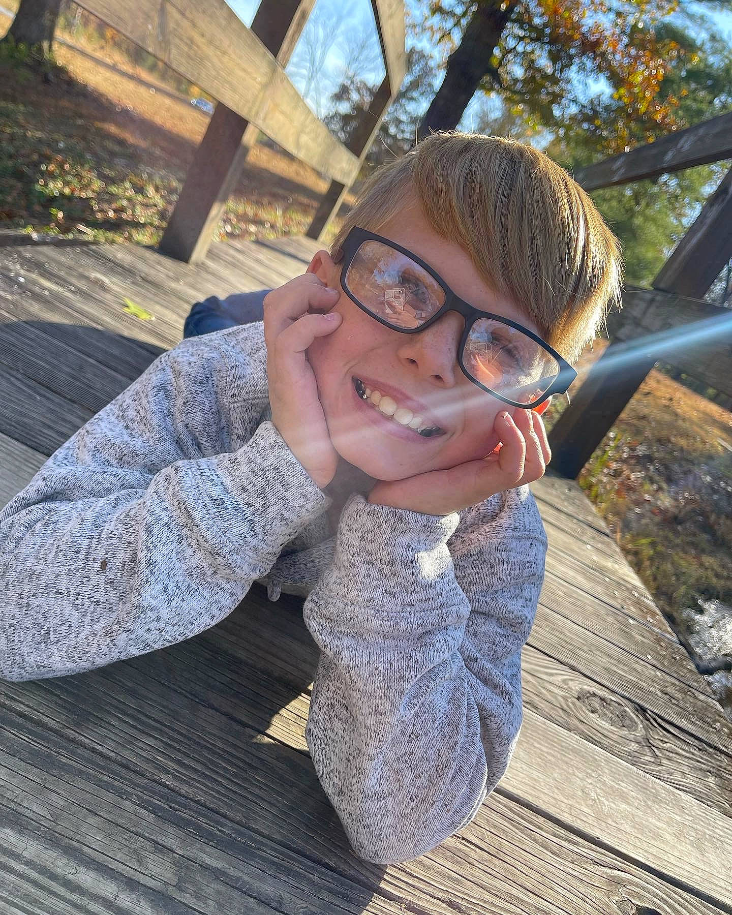 Blake joined the competition — help win amazing prizes! child, eyewear, finger, fun, glasses, grass, happy, joy, leisure, person, personal_protective_equipment, plant, recreation, sitting, smile, swing, thumb, toddler, tree, vision_care
