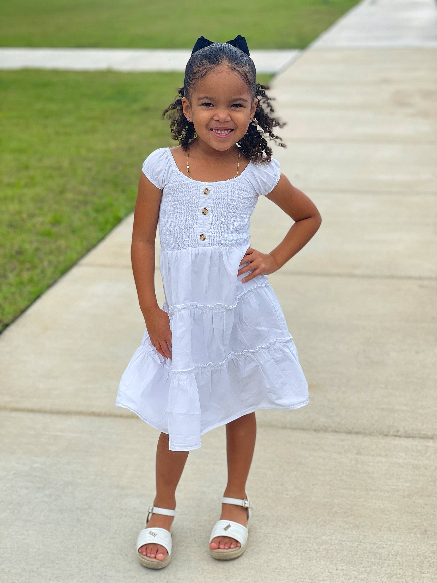 Maliyah is registered to the contest to win money with this photo: baby_toddler_clothing, day_dress, dress, face, fun, gesture, grass, hair, happy, head, joy, knee, neck, one_piece_garment, person, recreation, sleeve, smile, sunglasses, thigh