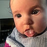 Rosie joined the competition — help win amazing prizes! baby, close_up, face, tongue_out, curious, child, infant, clothing, warm, soft_light, indoors, portrait, cute, skin, eyes, expression, person, young_child, cozy, head