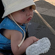 Mikael a rejoint le concours — aidez-le/la à gagner de superbes lots ! toddler, child, hat, bucket_hat, blue_clothing, sneaker, shoe, stroller, outdoor, pavement, side_view, sunlight, young_child, casual, summer, footwear, curious, baby, person, cute