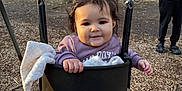 Raya is registered to the contest to win money with this photo: toddler, child, swing, playground, park, trees, blanket, jacket, pants, person, adult, nature, outdoor, woodchips, smile, happy, daylight, casual_clothing, fun, family