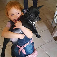 Pilou participe au concours pour gagner de l'argent avec cette photo : adult, affection, black_dog, casual_clothing, child, cute, dog, family, footwear, happy, holding, home_interior, indoor, kitchen, person, puppy, red_hair, smiling, standing, tile_floor