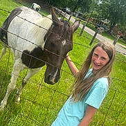 Amberlyn joined the competition — help win amazing prizes! child, girl, horse, animal, fence, outdoor, green_grass, tree, summer, petting, casual_clothing, long_hair, sunlight, nature, rural, pasture, happy, young, daytime, farm