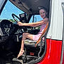 barefoot, candid, child, dashboard, dashboard_controls, door, girl, keys, pedals, pink_dress, seat, seatbelt, side_mirror, smile, steering_wheel, summer, sunlight, truck, vehicle_interior, window