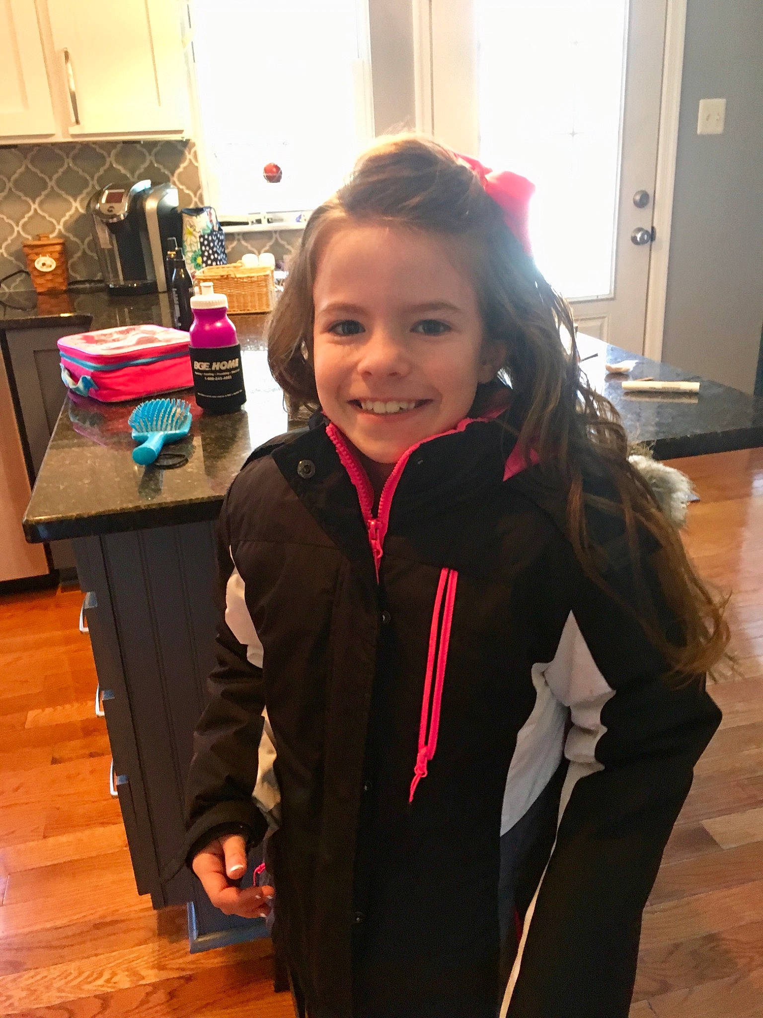 Karleigh joined the competition — help win amazing prizes! child, coat, face, head, jacket, joy, long_hair, outerwear, person, smile, standing, toddler, wood