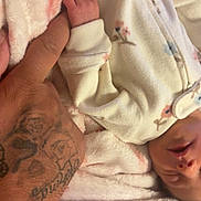 Laikelynn joined the competition — help win amazing prizes! baby, infant, hand, tattoo, blanket, onesie, sleeping, floral_pattern, skin, fingers, cuddle, comfort, soft_texture, closeup, human, rest, peaceful, warmth, parent, bond
