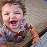Xander is registered to the contest to win money with this photo: toddler, child, curly_hair, smiling, laughing, bear_print, shirt, carpet, toy, indoor, playroom, furniture, hand, foot, happy, person, blur, closeup, excited, cute