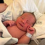 newborn, baby, sleeping, hospital, blanket, wristband, infant, skin, hand, face, closed_eyes, resting, cute, tiny, hospital_bed, soft, peaceful, person, healthcare, newborn_baby