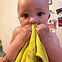 Stylles is registered to the contest to win money with this photo: baby, child, infant, yellow_cloth, hand, face, eyes, skin, indoor, curious, close_up, grip, texture, background_blur, photography, person, holding, soft_light, portrait, nibbling