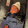 newborn, baby, sleeping, car_seat, safety_straps, hat, clothing, infant, bundle, red_button, closeup, indoors, child, cute, peaceful, resting, face, person, seat, fabric