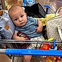 Stylles is registered to the contest to win money with this photo: baby, shopping_cart, toy, bag, clothing, floor, supermarket, aisle, person, child, socks, blue_shirt, striped_shirt, expression, shopping, indoor, retail, infant, cute, gaze