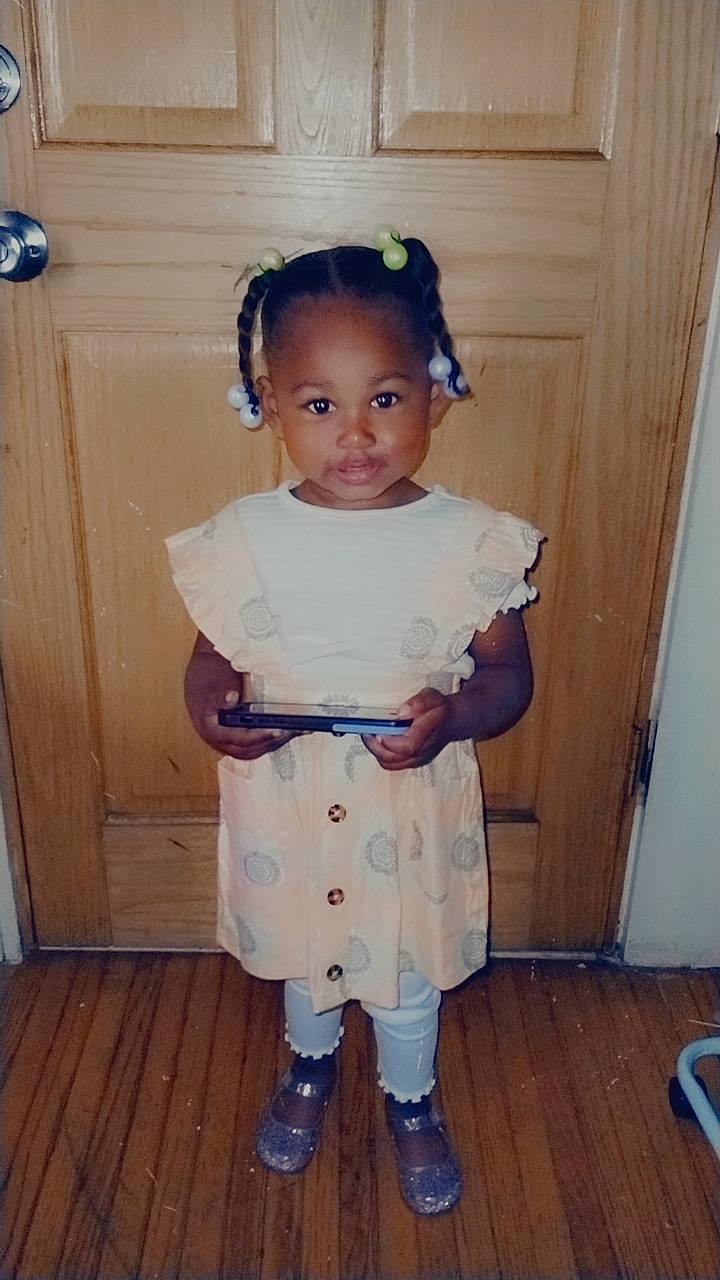 Legacy is registered to the contest to win money with this photo: baby_toddler_clothing, blue, child, costume, day_dress, door, dress, face, fashion_accessory, fashion_design, flooring, formal_wear, hair, hardwood, head, pattern, person, sleeve, toddler, wood