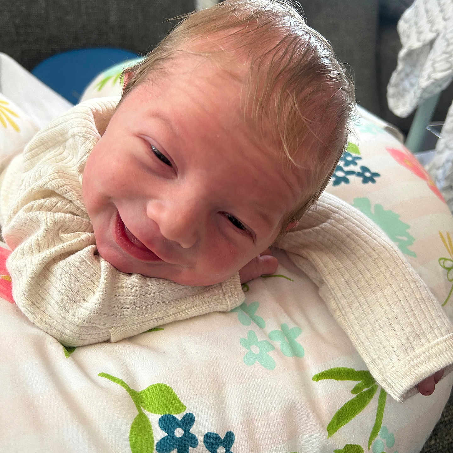 Grayson is registered to the contest to win money with this photo: baby, babywear, blanket, clothing, couch, cozy, cute, face, flower_pattern, happy, head, indoor, infant, newborn, person, pillow, portrait, resting, skin, smile