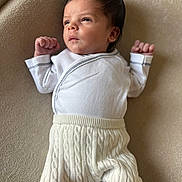 Gianni a rejoint le concours — aidez-le/la à gagner de superbes lots ! baby, beige_background, cozy, cute, expression, face, indoors, infant, knit_pants, lying_down, newborn, person, portrait, raised_fists, skin, sleepwear, small_hands, soft_lighting, white_clothing, young_child
