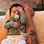 baby, infant, sleeping, pacifier, legs, tattoo, knit_pants, long_sleeve_shirt, indoor, carpet, blanket, hand, face, person, relaxing, cozy, cute, child, pacifier_clip, resting