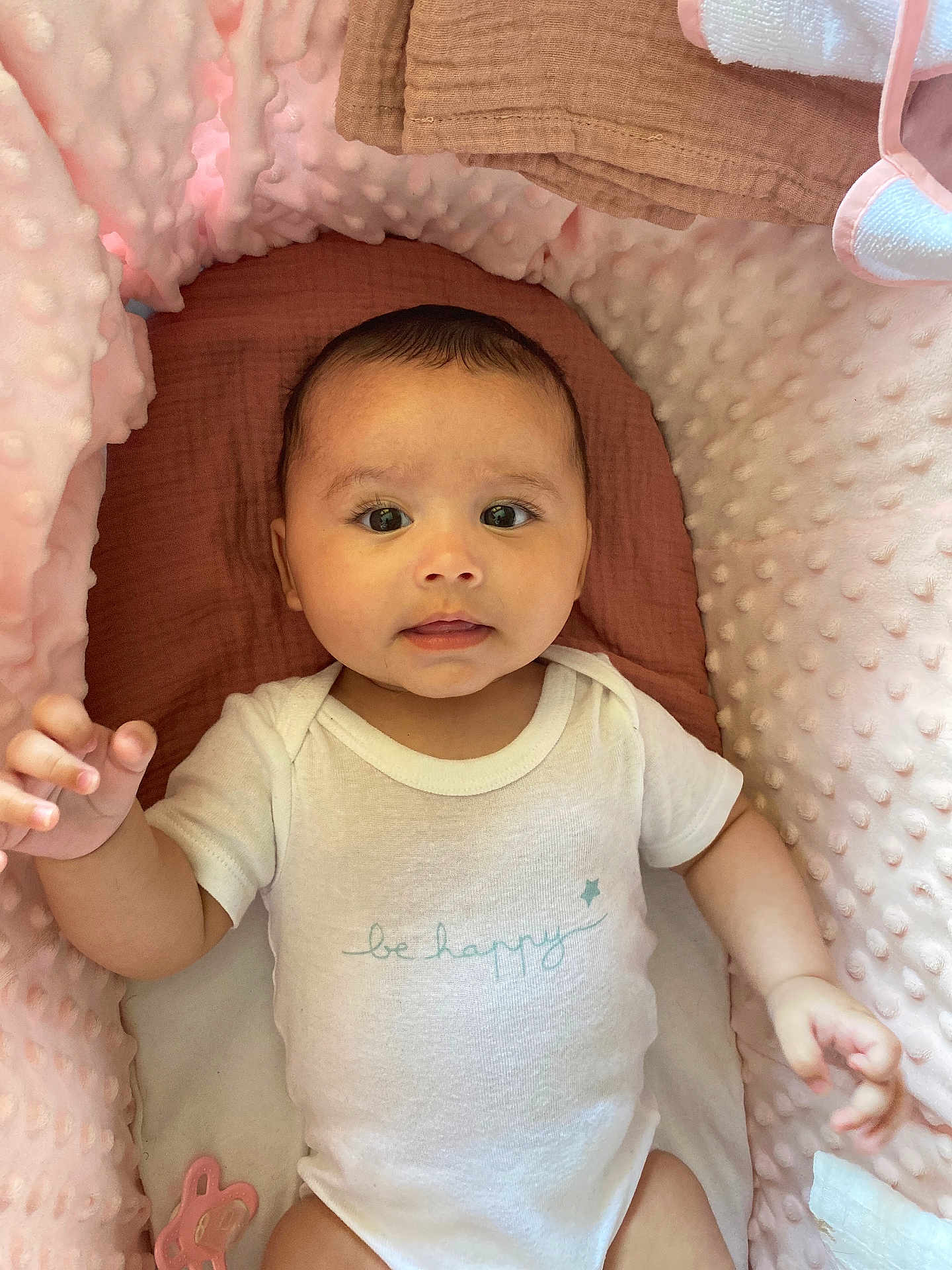 Aylé a rejoint le concours — aidez-le/la à gagner de superbes lots ! baby, infant, onesie, white_clothing, be_happy_text, pink_cushion, brown_blanket, soft_texture, cute, child, portrait, lying_down, indoor, closeup, hand, face, expression, newborn, comfortable, cozy