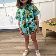 Raelynn is registered to the contest to win money with this photo: blue_wall, brown_hair, casual_clothing, child, fashion, floral_shirt, full_body, happy, home, indoor, playroom, portrait, smiling, sneakers, standing, text_overlay, toy_table, tropical_pattern, white_paneling, wooden_floor