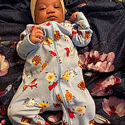 Nylah is registered to the contest to win money with this photo: baby, blanket, bow, child, colorful, cute, expression, face, floral_pattern, hand, headband, indoors, infant, lying_down, newborn, onesie, person, portrait, sleepwear, soft_fabric