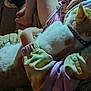 child, cat, snuggling, pajamas, collar, paw_print, blanket, arm, legs, indoor, pet, cozy, fur, soft_lighting, close_up, human, animal, comfort, resting, warm