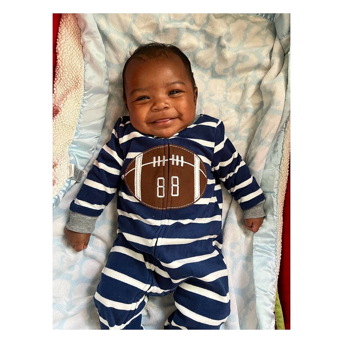 Kaiser is registered to the contest to win money with this photo: arm, baby, baby_toddler_clothing, collar, comfort, electric_blue, face, gesture, happy, head, jersey, joy, outerwear, person, product, sleeve, smile, sportswear, street_fashion, t_shirt