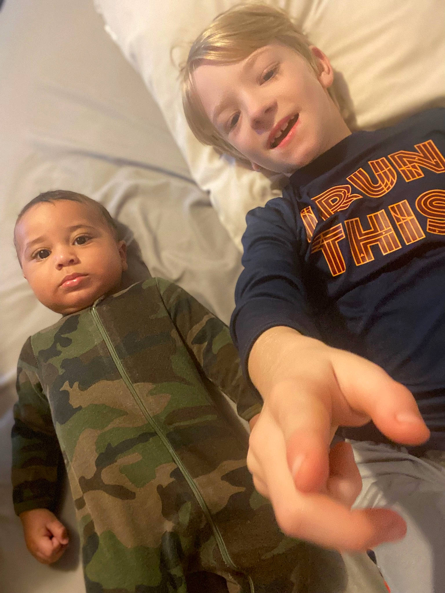 Braiden is registered to the contest to win money with this photo: baby_toddler_clothing, camouflage, child, comfort, eye, face, finger, fun, gesture, happy, head, human_body, military_camouflage, person, skin, sleeve, smile, t_shirt, textile, thumb