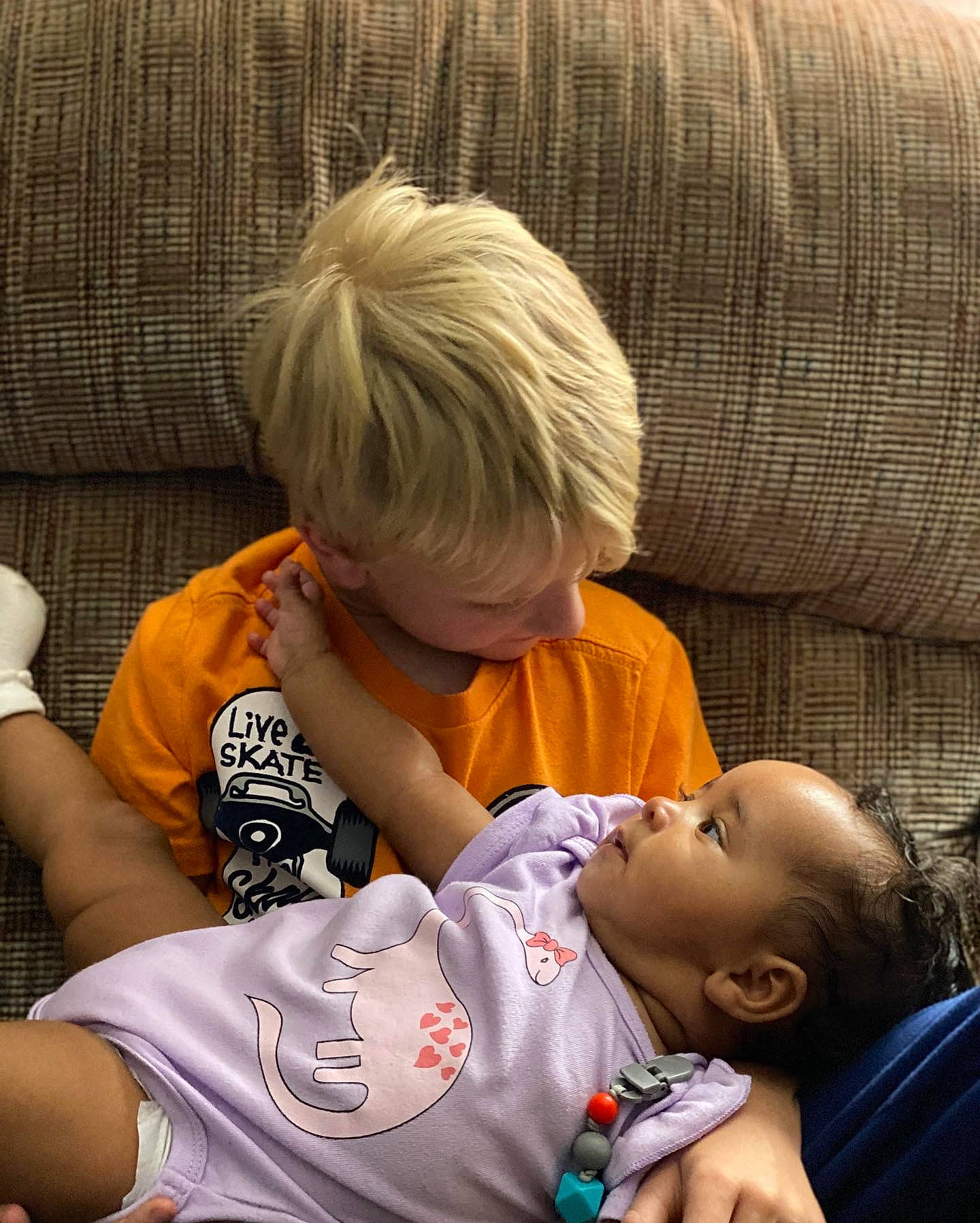 Aiden is registered to the contest to win money with this photo: baby, bangs, child, comfort, couch, elbow, facial_expression, fun, glasses, grass, hair, happy, interaction, joint, mammal, person, sharing, sitting, skin, t_shirt