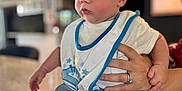 Cameron participe au concours pour gagner de l'argent avec cette photo : baby, bib, blurred_background, casual_clothing, child, countertop, cute, feet, focus, hand, indoor, infant, jeans, person, portrait, ring, sitting, speckled_surface, support, young