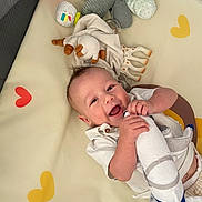 Cameron participe au concours pour gagner de l'argent avec cette photo : baby, child, colorful, crawling_mat, cute, fun, happy, heart_shape, holding, indoor, infant, joyful, playpen, plush_toy, smiling, soft_toy, stuffed_animal, toy, white_clothing, young