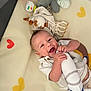 baby, child, colorful, crawling_mat, cute, fun, happy, heart_shape, holding, indoor, infant, joyful, playpen, plush_toy, smiling, soft_toy, stuffed_animal, toy, white_clothing, young