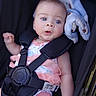 Sylvia is registered to the contest to win money with this photo: baby, blue_eyes, stroller, infant, child, safety_harness, blanket, pink_clothing, cute, portrait, outdoor, person, face, small_hand, soft_texture, young_child, seated, expression, close_up, adorable