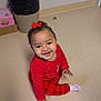 toddler, child, smiling, red_clothing, bow, sitting, floor, indoors, happy, person, baby, plaid_pants, sock, trash_can, box, hair, cute, portrait, young_child, playful