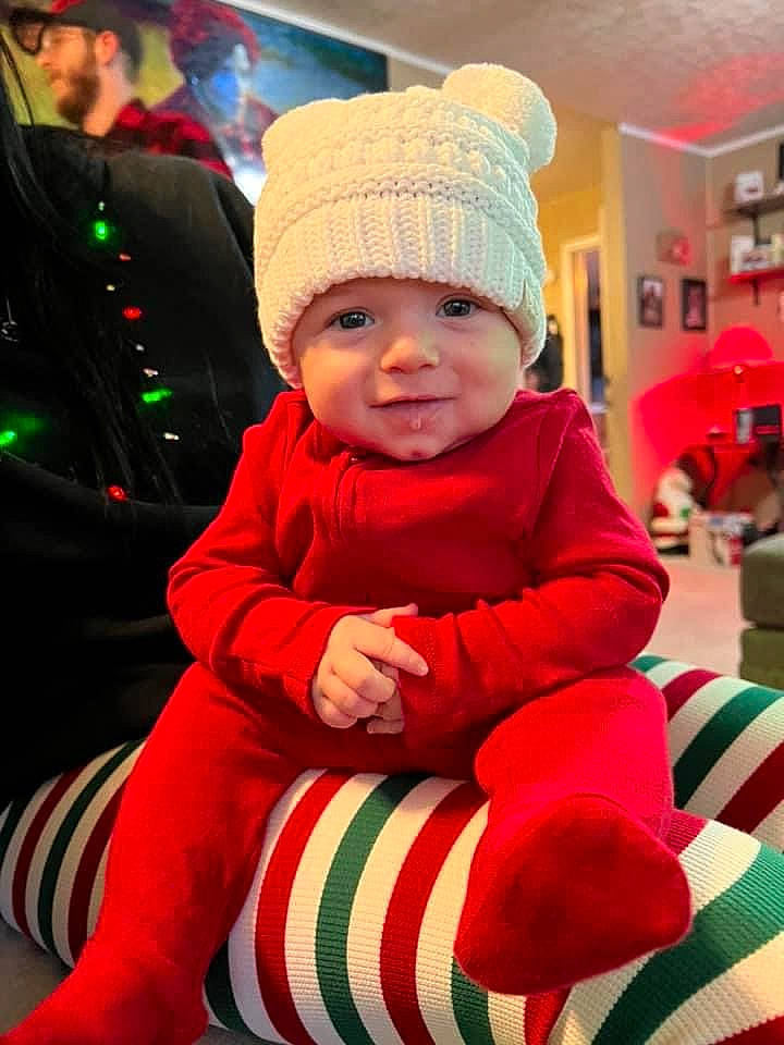 Daxton is registered to the contest to win money with this photo: baby, baby_toddler_clothing, cap, child, christmas, christmas_decoration, christmas_eve, christmas_ornament, event, fun, happy, headwear, holiday, person, red, santa_claus, sleeve, smile, standing, toddler