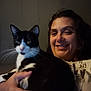 Pepper joined the competition — help win amazing prizes! person, cat, indoor, smiling, black_and_white_cat, holding, seated, wall, human_face, whiskers, fur, casual_clothing, relaxed, pet, domestic_animal, portrait, hand, close_up, comfort, home