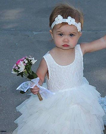 Ireland is registered to the contest to win money with this photo: baby_toddler_clothing, bridal_clothing, bridal_party_dress, bridal_veil, dress, embellishment, flash_photography, flower, gown, hand, happy, headgear, headpiece, headwear, human_body, iris, person, petal, pink, shoulder