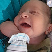 Makiah is registered to the contest to win money with this photo: newborn, baby, smiling, sleeping, mitten, blanket, clothing, face, infant, resting, cute, cozy, person, portrait, hand, soft, young, peaceful, indoors, closeup
