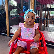 Ellen joined the competition — help win amazing prizes! baby, blue_headband, bracelet, child, clothing, curious, expression, floor, footwear, furniture, headwear, indoor, mesh_screen, person, pink_dress, playground, portrait, red_chair, sitting, toddler
