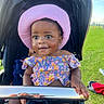Ellen is registered to the contest to win money with this photo: baby, child, colorful_clothing, cute, face, green_grass, happy, hat, outdoor, park, person, pink_hat, playful, portrait, reflection, smiling, stroller, summer, sunny, toddler