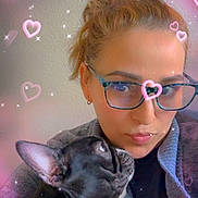 Lady joined the competition — help win amazing prizes! person, dog, glasses, heart_overlay, sparkles, indoor, portrait, black_dog, white_chest, short_hair, eyewear, affection, cute, pet, cozy, love, casual_clothing, close_up, looking_up, warm_lighting