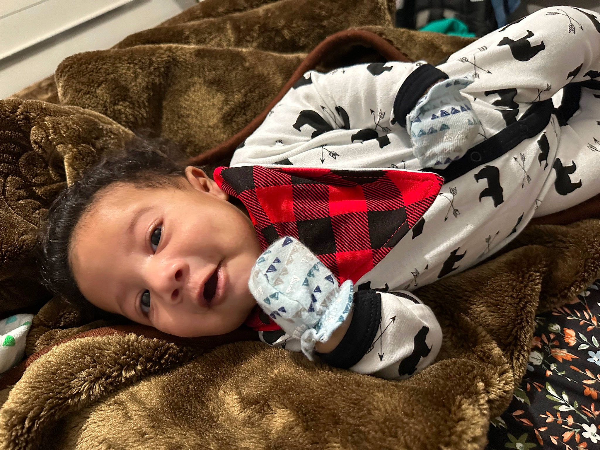 Joaquin is registered to the contest to win money with this photo: bag, carmine, child, comfort, cool, fur, grass, hairstyle, happy, human_leg, luggage_and_bags, pattern, person, personal_protective_equipment, plaid, sitting, tartan, toddler, tree, winter