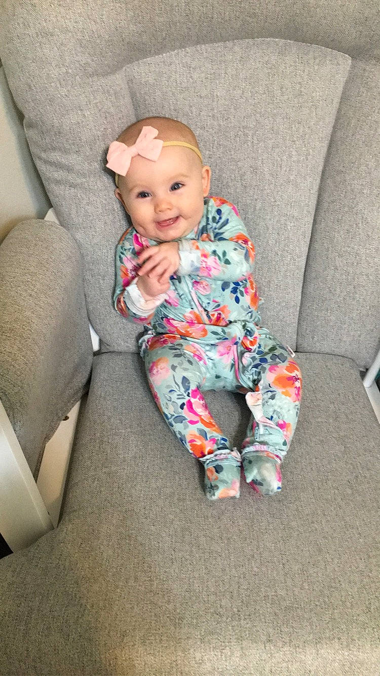 Brixlyn is registered to the contest to win money with this photo: baby, baby_toddler_clothing, cheek, child, comfort, finger, flooring, headwear, human_body, human_leg, joy, knee, leg, linens, pattern, person, sitting, sleeve, smile, sock