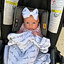 Halston is registered to the contest to win money with this photo: baby, infant, car_seat, blanket, bow, headband, face, person, child, safety, seat, clothing, cute, newborn, wrapped, indoors, warning_labels, soft, pink, expression