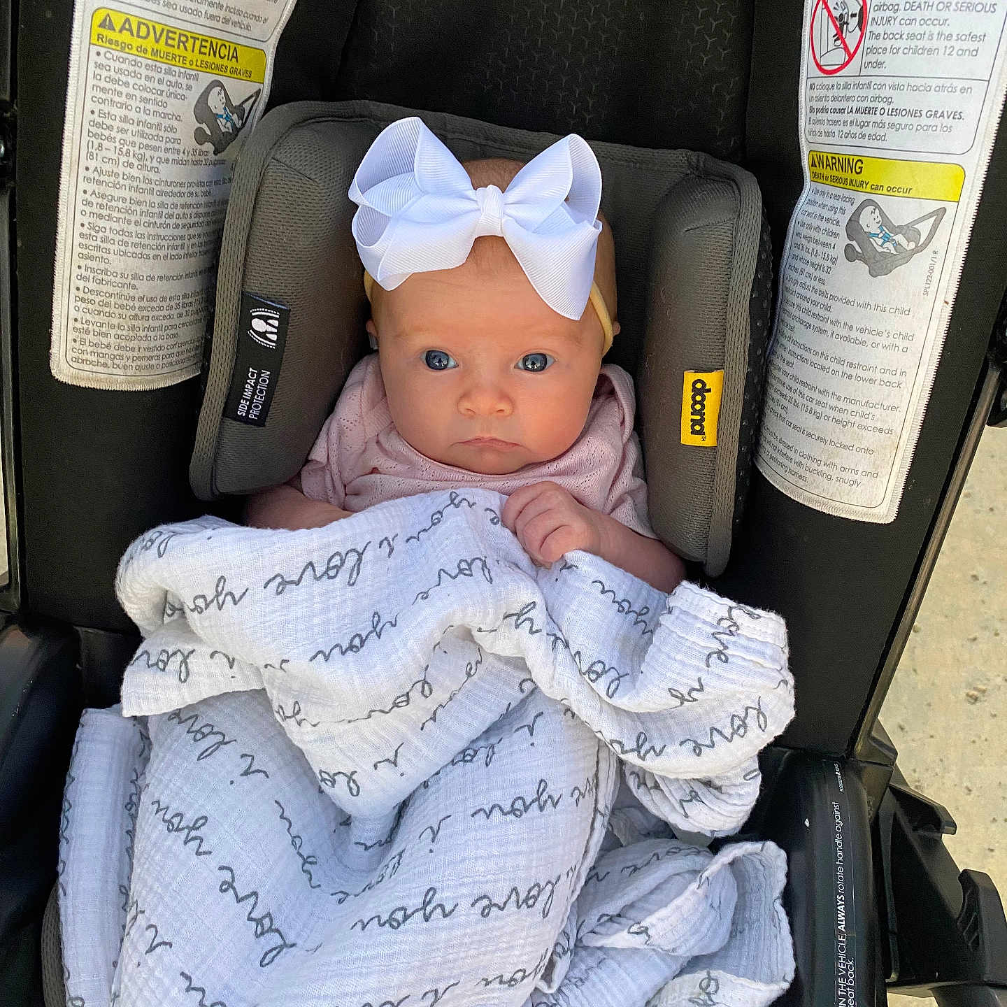 Halston is registered to the contest to win money with this photo: baby, blanket, bow, car_seat, child, clothing, cute, expression, face, headband, indoors, infant, newborn, person, pink, safety, seat, soft, warning_labels, wrapped