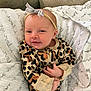 baby, infant, onesie, leopard_print, headband, bow, blanket, smile, face, hands, cozy, comfort, couch, cute, sleepwear, newborn, person, portrait, indoor, soft