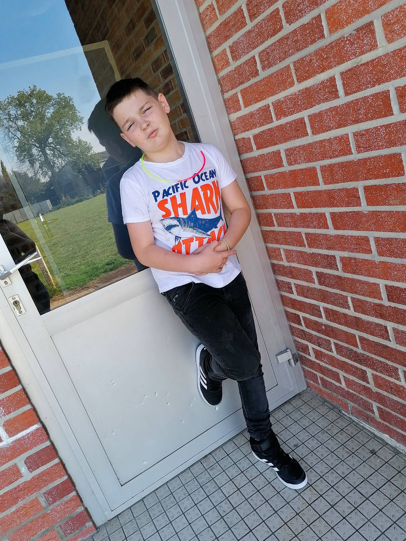 Bryan a rejoint le concours — aidez-le/la à gagner de superbes lots ! brick, child, cool, footwear, house, jeans, leg, outerwear, person, photography, shoe, standing, t_shirt, textile, top, window