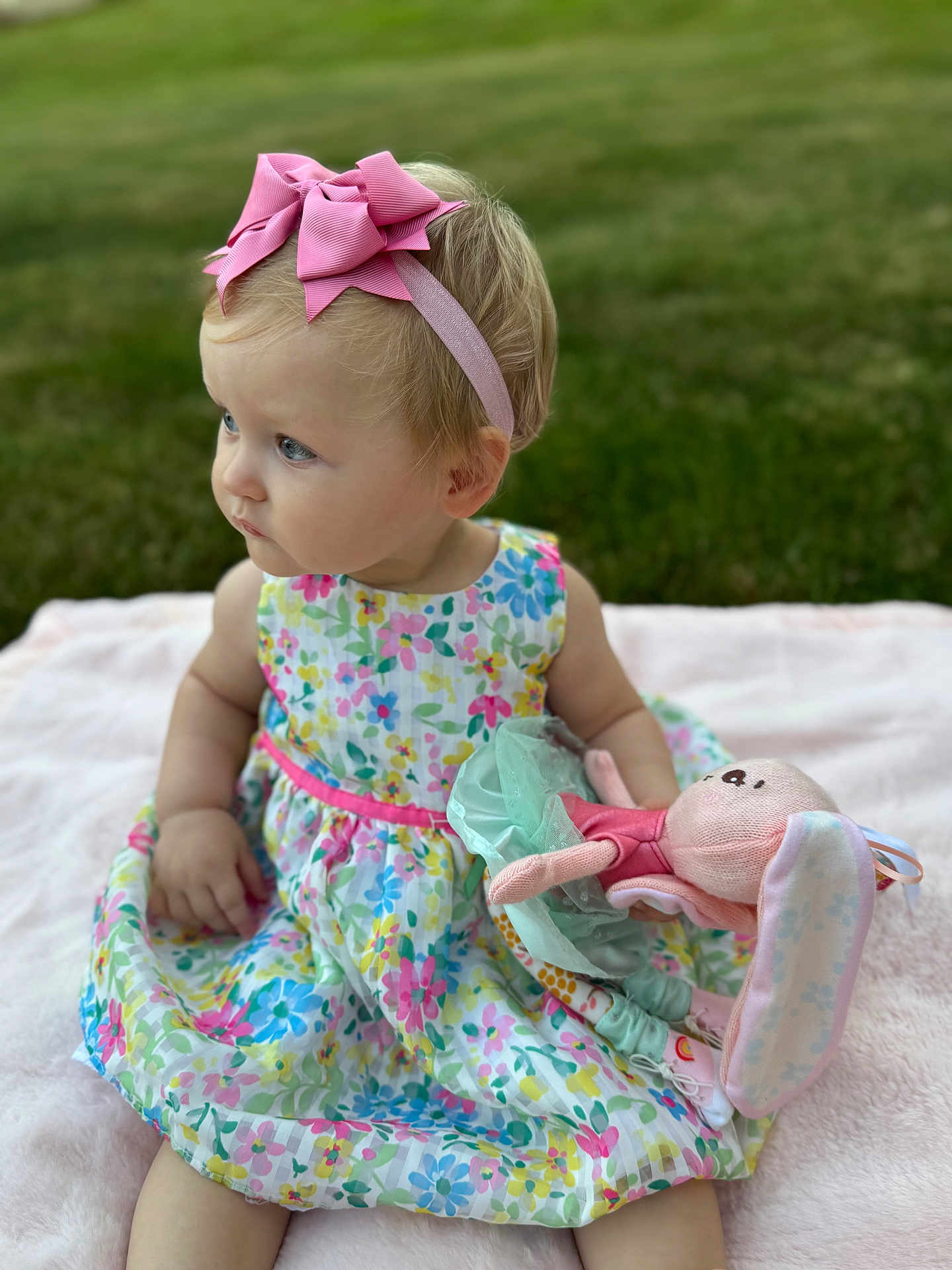Maria is registered to the contest to win money with this photo: toddler, child, baby, outdoor, grass, blanket, dress, floral_pattern, headband, pink_bow, stuffed_animal, bunny, toy, sitting, cute, portrait, soft_light, summer, playtime, happy